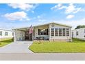 Exterior view of a manufactured home with a covered carport and landscaped lawn at 6505 Raintree Ne Ln, Winter Haven, FL 33881