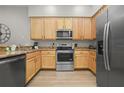 Modern kitchen with stainless steel appliances and light wood cabinets at 3050 Pirates Retreat Ct # 502, Kissimmee, FL 34747