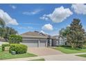 Two-story house with a three-car garage and well-maintained landscaping under a bright sky at 3066 Santa Marcos Dr, Clermont, FL 34715