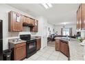 Kitchen with dark wood cabinets, black appliances, and granite countertops at 6304 Red Herring Dr, Winter Haven, FL 33881