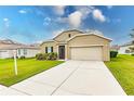 Tan one-story house with a two-car garage and landscaped yard at 6048 Forest Ridge Ln, Winter Haven, FL 33881