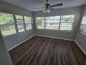 Bright sunroom with multiple windows and dark brown wood-look flooring at 5603 Perrine Dr, Orlando, FL 32808