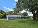 Single-story blue home with attached garage and large oak tree at 4810 N Galloway Rd, Lakeland, FL 33810
