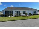 Rear view of a house with a screened porch and landscaping at 4415 Casey Ct, The Villages, FL 32163