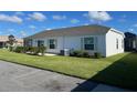Side view of a house, showing vinyl siding and landscaping at 4415 Casey Ct, The Villages, FL 32163