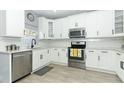 Modern kitchen with white shaker cabinets and stainless steel appliances at 7126 Regina Way, Orlando, FL 32819