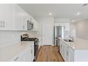 Modern kitchen with white cabinets, stainless steel appliances, and island at 2288 Canyon Oak Dr, Davenport, FL 33837