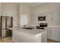Modern kitchen with island, stainless steel appliances, and light cabinets at 1592 Ellesmere Ave, Haines City, FL 33844