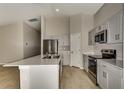 Modern kitchen with island, stainless steel appliances, and light cabinets at 1592 Ellesmere Ave, Haines City, FL 33844