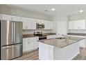 Modern kitchen with white cabinets, stainless steel appliances, and an island at 1615 Ellesmere Ave, Haines City, FL 33844