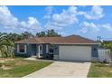 Newly built home with a blue exterior, two-car garage, and neatly landscaped yard at 4720 Saint Helena Rd, Lake Wales, FL 33898