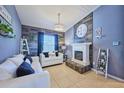 Cozy living room with white couches, a fireplace, and a rustic accent wall at 612 Chicago Way, Dundee, FL 33838