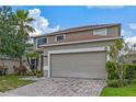 Beige two-story house with a brown roof and a two-car garage at 4615 Cumbrian Lakes Dr, Kissimmee, FL 34746