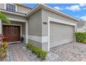 Two-car garage with a beige door and a paved driveway at 4615 Cumbrian Lakes Dr, Kissimmee, FL 34746