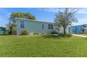 View of a light green mobile home on a grassy lot at 4961 Deerwood Dr, Lakeland, FL 33810