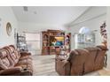 Bright living room with large TV, comfortable seating, and hardwood floors at 163 Andalusia Loop, Davenport, FL 33837