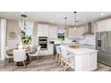 Modern kitchen with white cabinets, island, and stainless steel appliances at 1050 Silverlake Blvd, Lake Alfred, FL 33850