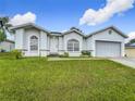 Single-story house with attached garage, landscaping, and a well-maintained lawn at 7713 Manor Dr, Lakeland, FL 33810