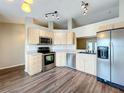 L-shaped kitchen with stainless steel appliances and wood-look flooring at 7713 Manor Dr, Lakeland, FL 33810