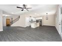 Open floor plan with modern kitchen, stainless steel appliances, and gray vinyl plank flooring at 7737 Somersworth Dr, Kissimmee, FL 34747