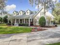 House exterior showcasing a charming front porch and landscaping at 1411 Hidden Oaks Bnd, Saint Cloud, FL 34771