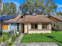 Tan house with brown roof, solar panels, and a small front yard at 1057 Old South Dr, Lakeland, FL 33811