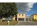 Two-story house with double garage and large tree in front at 5018 Strada Dr, Winter Haven, FL 33880