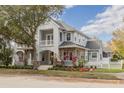 Two story house, light gray siding, stone accents, lush landscaping at 3366 Cat Brier Trl, Harmony, FL 34773