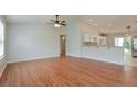 Open living space with hardwood floors and kitchen access at 2572 Berrington Loop, The Villages, FL 32162