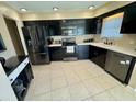 Modern kitchen featuring black cabinets, stainless steel appliances, and tile flooring at 3234 Bonnybrook S Dr, Lakeland, FL 33811