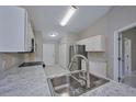 Kitchen features white cabinets, stainless steel appliances, and a marble countertop at 6294 Arborea Dr, Indian Lake Estates, FL 33855