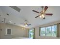 Spacious living room with high ceilings, ceiling fans, and large windows at 6294 Arborea Dr, Indian Lake Estates, FL 33855