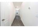 Clean and spacious hallway featuring gray vinyl flooring and white walls at 13470 Leaping Water Way, Astatula, FL 34705