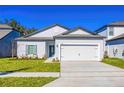 Newly built home with white exterior, two-car garage, and landscaping at 13486 Leaping Water Way, Astatula, FL 34705
