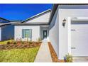 Front entrance of a new home with walkway, landscaping, and two-car garage at 13486 Leaping Water Way, Astatula, FL 34705