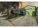 Front view of a green house with a driveway and landscaping at 1111 Royal Ridge Dr, Davenport, FL 33896