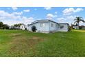 Rear view of manufactured home with grassy yard at 1610 Reynolds Rd # 159, Lakeland, FL 33801