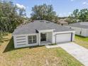 New construction home, single story, gray roof, white exterior, driveway, and grassy yard at 1312 Congo Dr, Poinciana, FL 34759