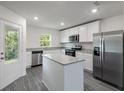 Modern kitchen with stainless steel appliances, white cabinets, and granite countertops at 576 Bay Leaf Dr, Poinciana, FL 34759