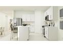 Modern kitchen with white cabinets, stainless steel appliances and island at 2033 Lasso Loop, Eagle Lake, FL 33839