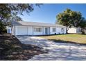 Newly renovated single story home with a white exterior, gray accents, and a neatly landscaped lawn at 3733 Hill St, Lakeland, FL 33812
