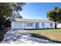 Newly renovated single story home with a white exterior, gray accents, and a neatly landscaped lawn at 3733 Hill St, Lakeland, FL 33812