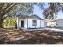 Newly renovated home with a gray roof, white exterior, and a spacious driveway at 1422 Bramblewood Dr, Lakeland, FL 33811