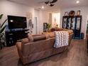 Spacious living room featuring a brown leather sectional sofa and built-in fireplace at 6855 Mossy Oak Ln, Lakeland, FL 33810