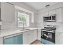 Renovated kitchen boasts modern white cabinets, stainless steel appliances, and quartz countertops at 7340 Daniel Webster Dr # 6, Winter Park, FL 32792