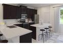 Modern kitchen featuring dark cabinetry, quartz countertops, and an island at 2651 Candied Apple Aly, Kissimmee, FL 34744