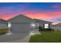 Two-car garage and front yard view at sunset at 524 Scenic Bluff Blvd, Lake Wales, FL 33853