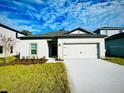 Newly built home with a two-car garage and well-manicured lawn at 13489 Leaping Water Way, Astatula, FL 34705