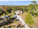 Elevated view of the property showcasing the home, driveway, and surrounding trees at 2468 Fawn Run, Oviedo, FL 32765
