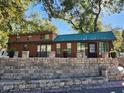 Log cabin with green metal roof and stone retaining wall at 25232 Ne 142Nd St, Fort Mc Coy, FL 32134